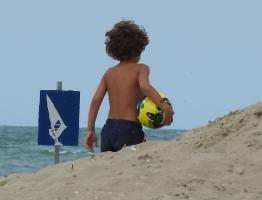 2017-281 Beach boy with curling haires and his baloon from behind