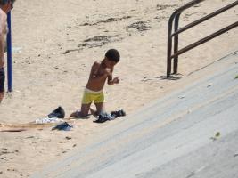 2018-076 Black boy climbing from the beach