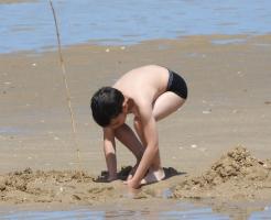 2018-011 Beach boy black speedo playing with sand