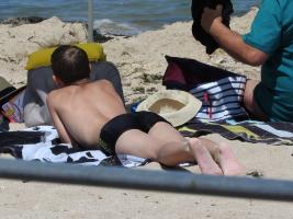 2018-085 Boy lying on the beach with a black swimsuit