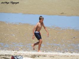 2016-099 Boy walking on the beach and his 2 brothers playing