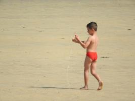 3017-329 Beach boy red speedo trying his kite