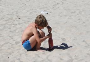 2020-024 Boy filling a bottle on the beach
