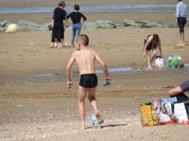 2017-67 Beach boy in black swim suite with his bucket and rake