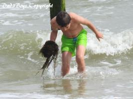 2017-57 Beachboy in the sea playing with algaes and a rope