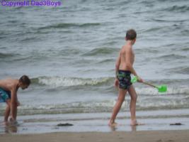 2017-149 The beach boy in green short holding a green showel