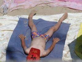 2018-063 Boy in swimsuit lying on the beach