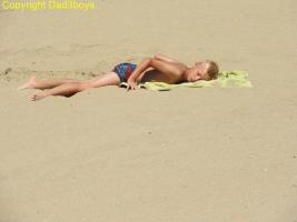 2017-117 Blond beach boy lying, sit, and rolling on the sand
