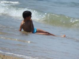 2016-087 Beach boy in blue speedo leaning in the water