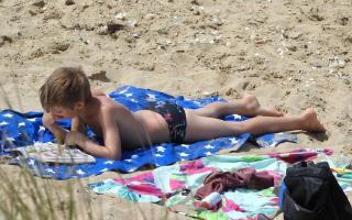 2020-003 Boy reading lying on the beach