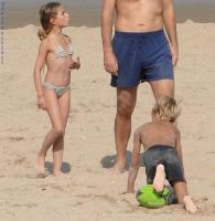 2011 - 77th album - Perfect little blond beach boy playing with his rugby green ball and 2 girls turning around him, and a monster overlaps him !