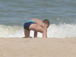 2011 - 65th album - Little beach boy in blue speedo, against the waves and a kidnapper