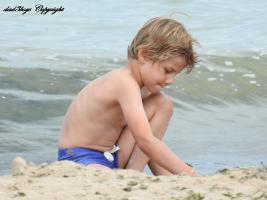 2016-122 Beach blond boy blue swimsuit digging close to the waves